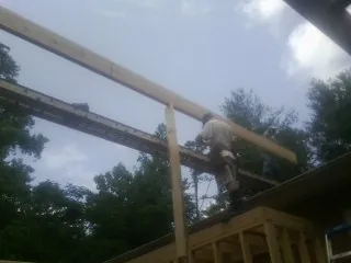 Carpenter setting a ridge beam over a new addition frame — Ice Dam Removal by Roofing Brothers in Jaffrey