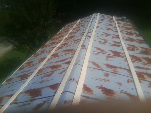 Rusted metal roof panels with new wood purlins before replacement — Storm Damage Roof Repair in Jaffrey by Roofing Brothers