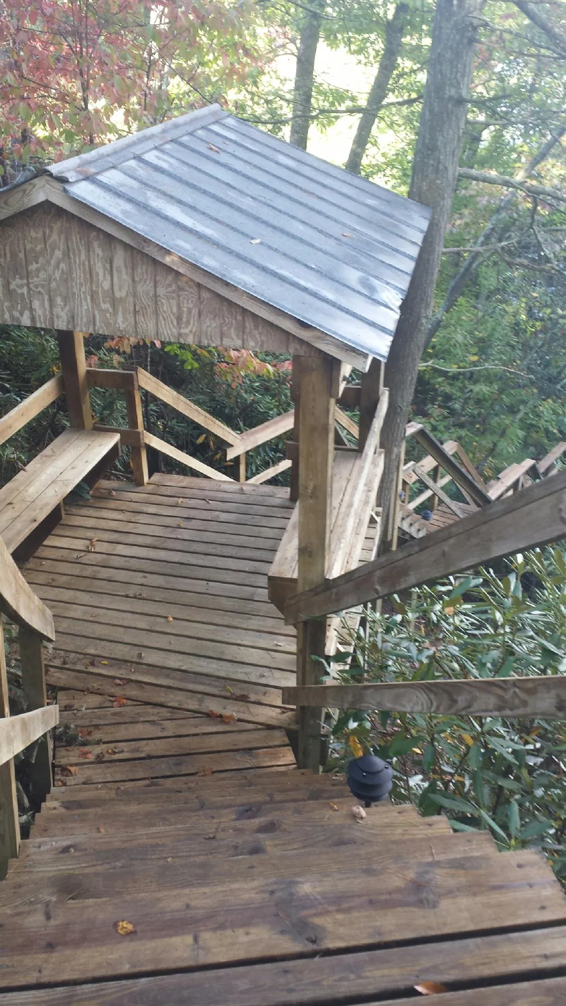 Metal roofed shelter over wooden steps on a wooded walkway — Skylight Repair & Installation work by our crew in Jaffrey